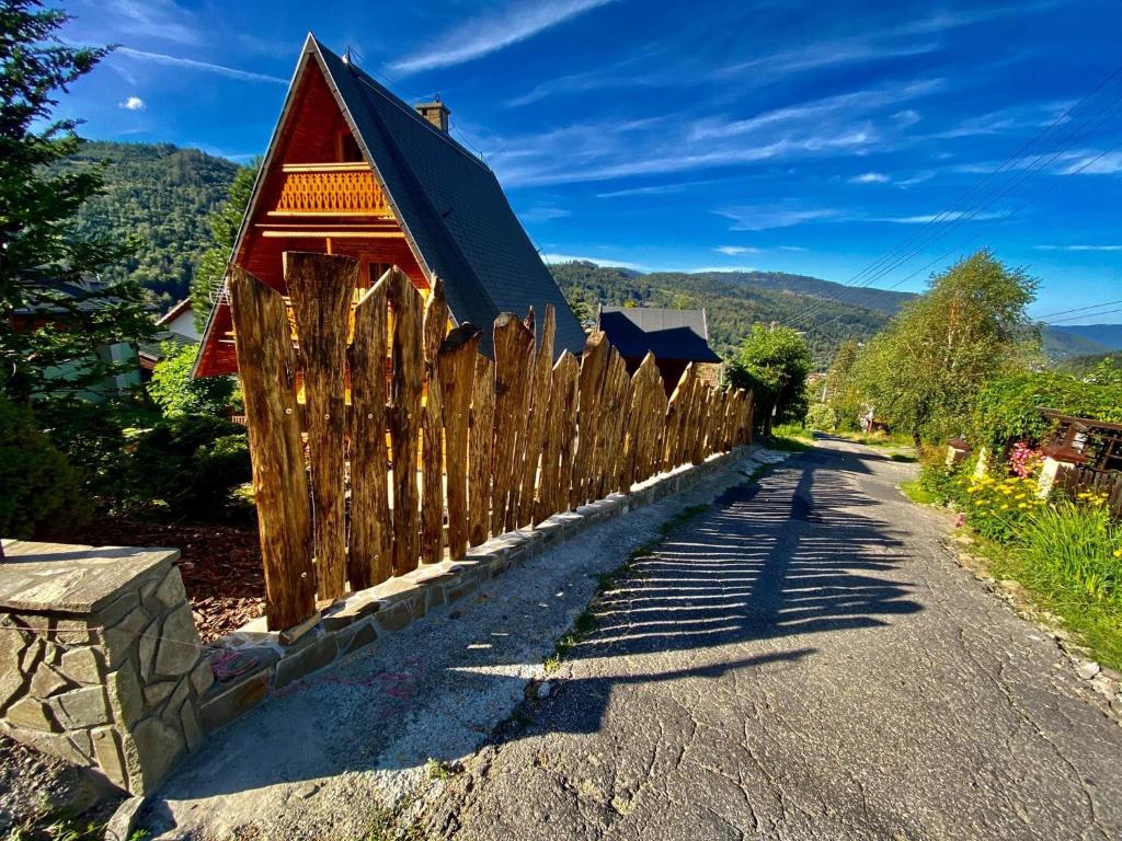 什切尔克SkiBajkowa Chata的房屋前的木栅栏