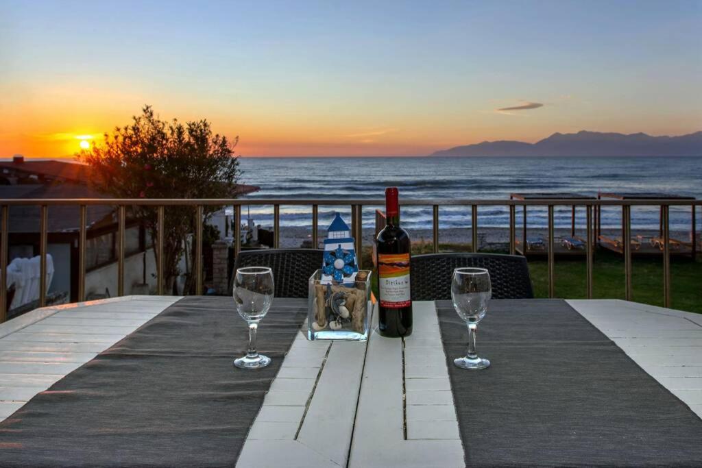 阿查拉维Maistro Beach House的一张桌子,上面放着一瓶葡萄酒和两杯酒