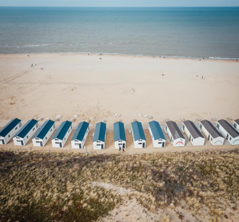 滨海卡特韦克Logeren aan Zee的海滩上一排海滩遮阳伞和椅子
