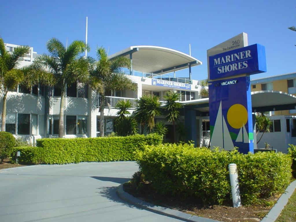 黄金海岸水手海岸俱乐部酒店的棕榈树建筑前的标志