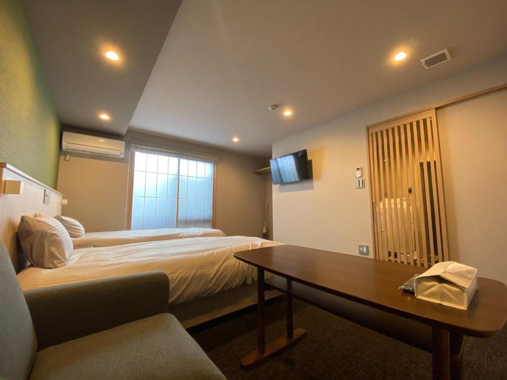 京都Gion Shirakawa - Vacation STAY 24774v的酒店客房设有两张床和一张桌子。
