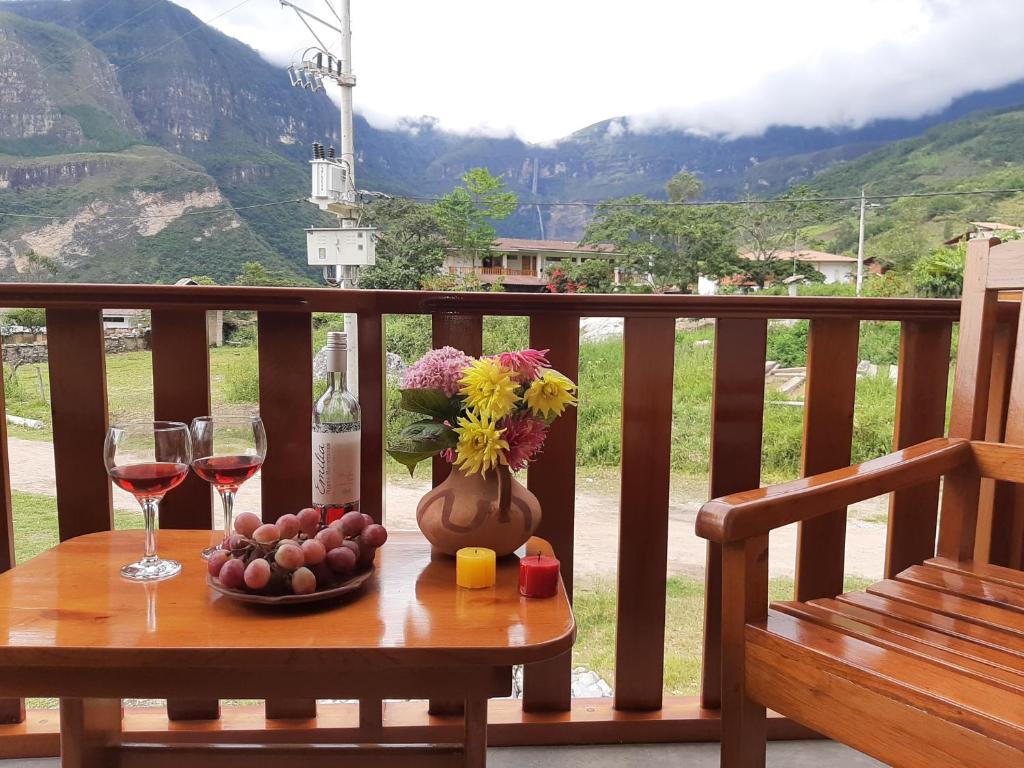 CocachimbaLa Posada de Gocta的一张桌子,上面放着两杯葡萄酒和花瓶