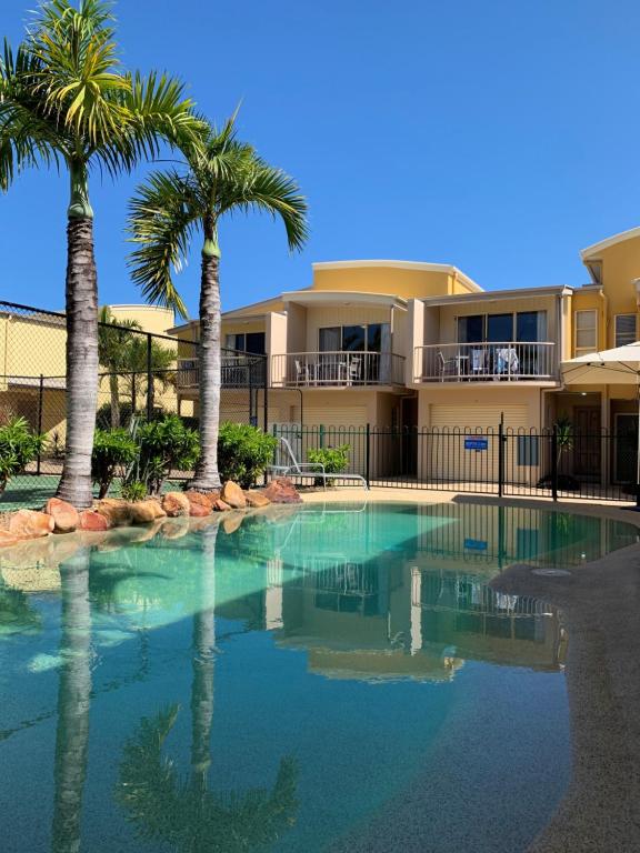库鲁姆海滩库鲁姆海滩逍遥度假酒店的一座楼前棕榈树游泳池