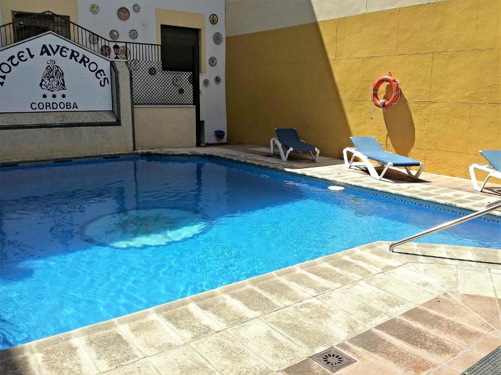 科尔多瓦阿威罗伊酒店的酒店的大型游泳池配有两把椅子