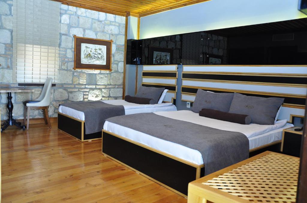 安塔利亚Kosa boutique hotel的一间卧室配有两张床、一张桌子和一把椅子