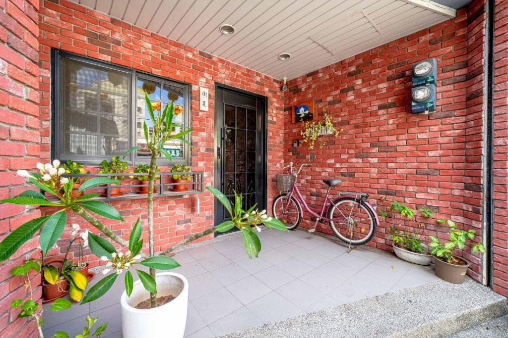 台南台南树夏民宿的停在砖墙旁的自行车,有植物