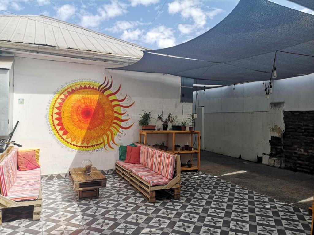 圣地亚哥Hostal Vitalia的一座建筑的一侧,设有一座带太阳壁画的庭院
