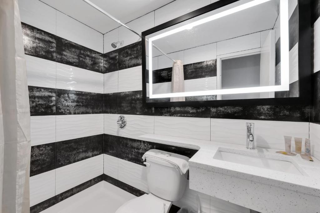 皇后区Hotel Mint JFK Airport的黑白浴室设有卫生间和水槽
