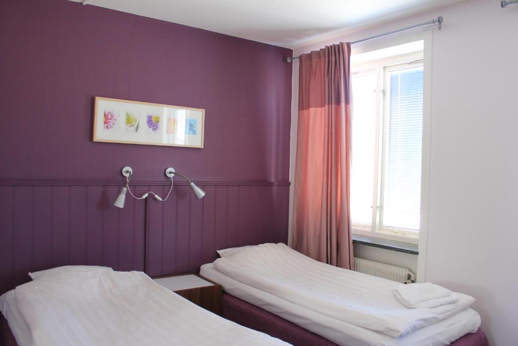 耶夫勒特斯托卡酒店的紫色墙壁和窗户的客房内的两张床