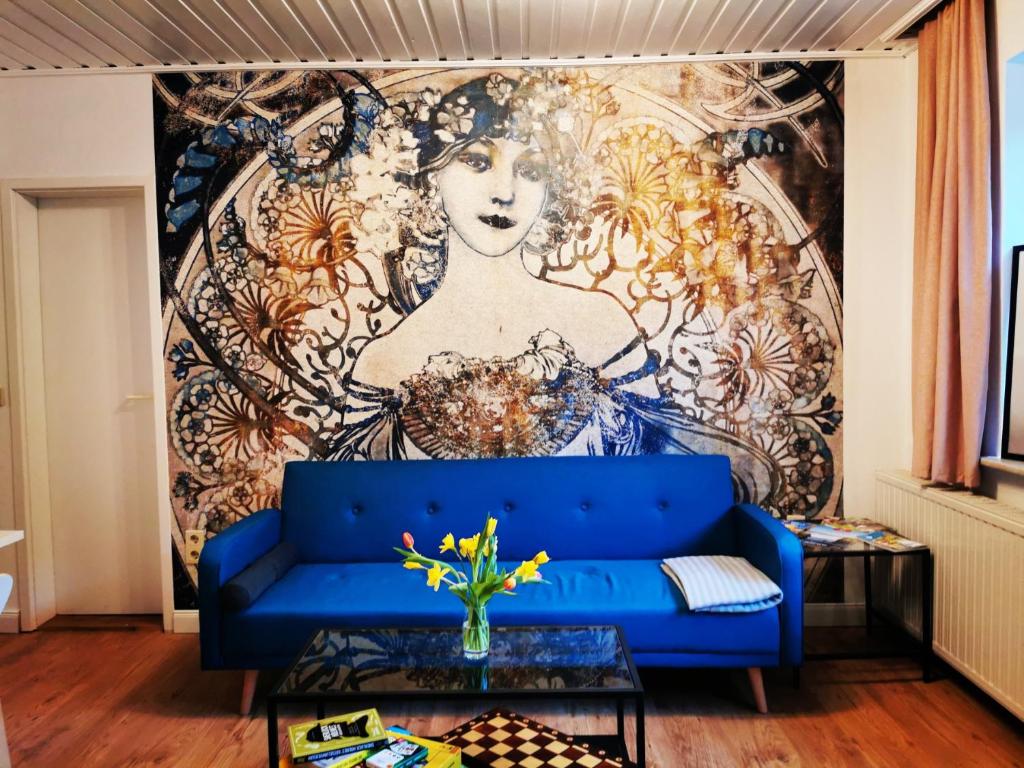 拉特诺Villa Rapunzel的客厅壁画前配有蓝色沙发