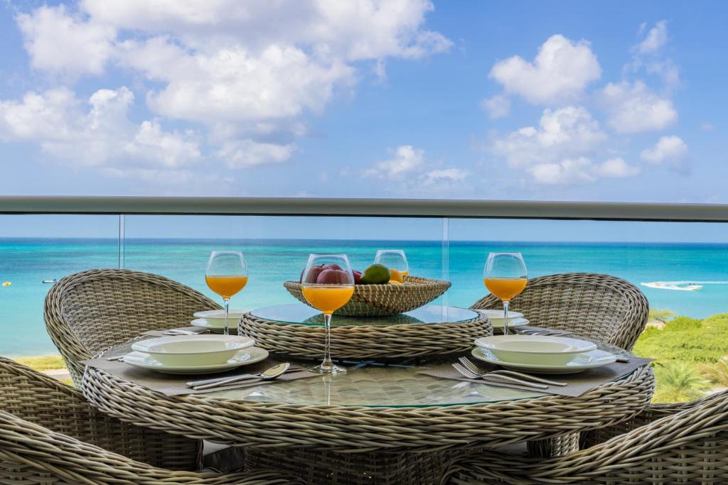 棕榈滩Azure Beach Residences的一张桌子,上面放着一碗水果和酒杯