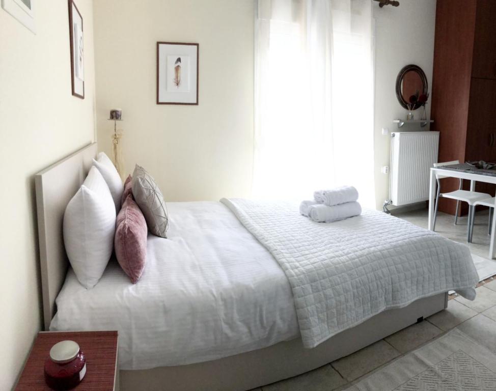 科扎尼Stergios_Apartments 05的卧室配有带枕头和桌子的白色床