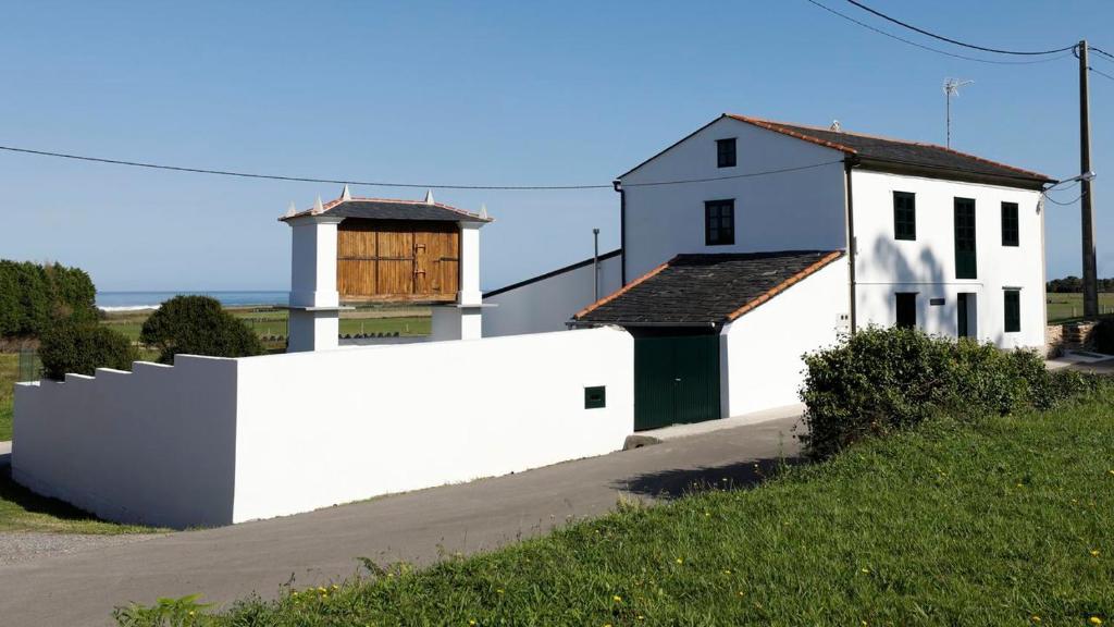 里瓦德奥A Minguxaina的一栋白色房子,旁边是白色的栅栏