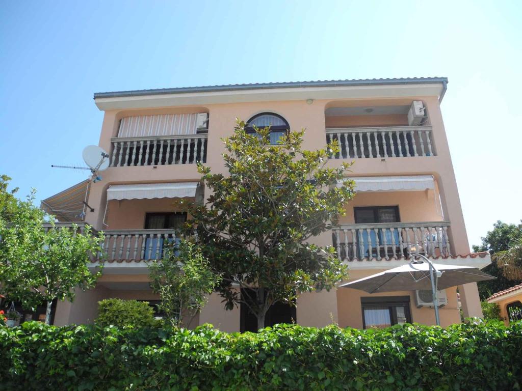 茨里克韦尼察Apartments in Crikvenica 41042的带阳台和树的棕褐色建筑