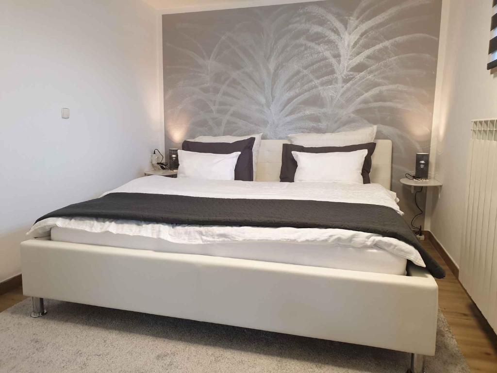 波斯托伊纳Apartment in Postojna 40241的卧室配有白色大床和黑白色枕头