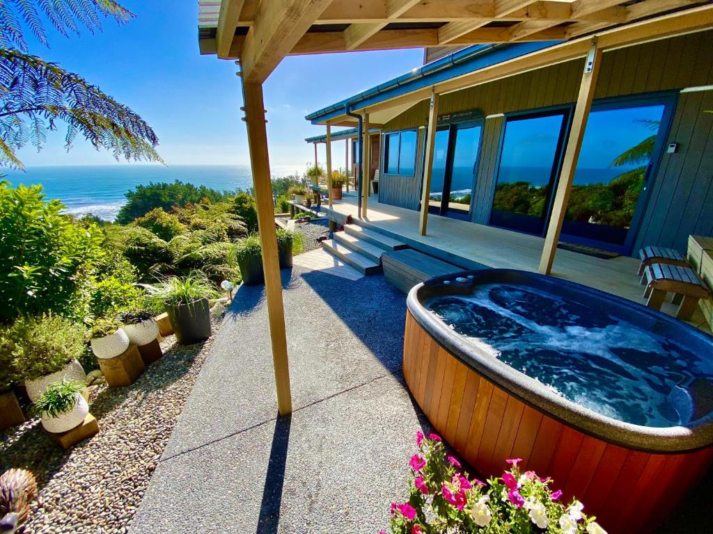 普纳凯基Tasman Sea Retreat的房屋门廊上的热水浴池