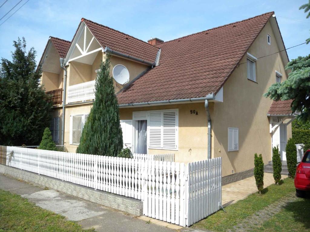 鲍洛通凯赖斯图尔Apartments in Balatonkeresztur 37924的前面有白色围栏的房子