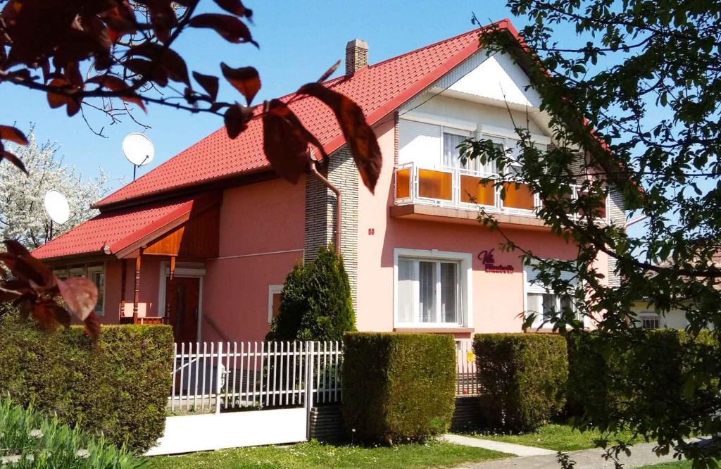 鲍洛通凯赖斯图尔Holiday home in Balatonkeresztur 37078的红色屋顶的粉红色房子