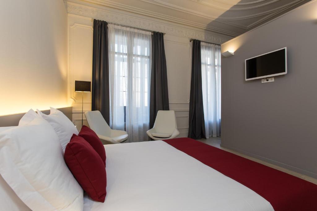 巴塞罗那加泰罗尼亚依扎拉广场住宿加早餐旅馆的酒店客房,配有床和电视