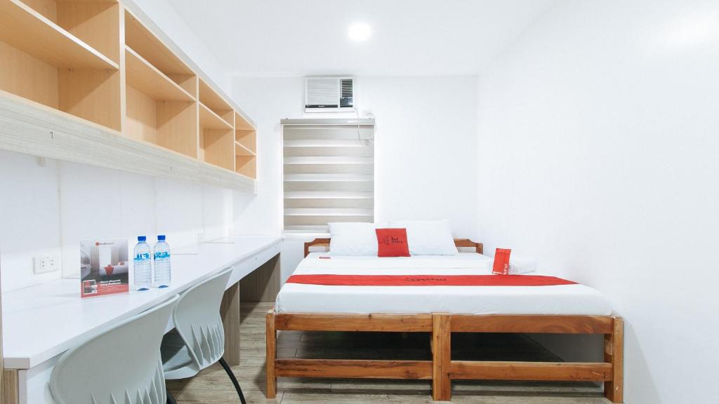 马尼拉RedDoorz Plus @ 1318 Residences的小房间设有床和书架