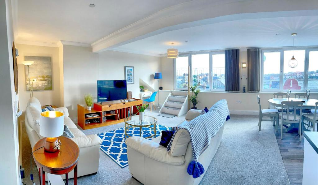斯卡伯勒Scarborough-Penthouse, with private balcony, lift and parking的一间带白色家具的客厅和一间餐厅
