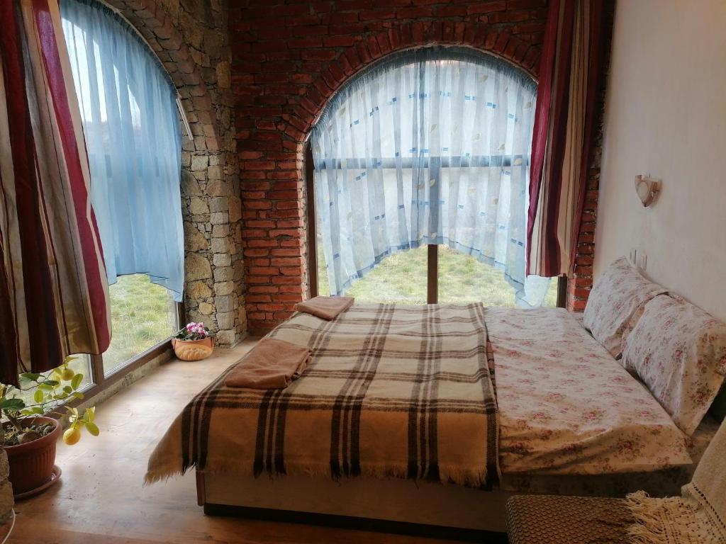 卡洛费尔Лилянината къща的卧室在窗户前配有一张床