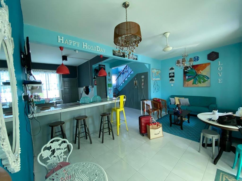 仙本那Suhana HomeStay Semporna - Cozy Home的厨房以及带蓝色墙壁和凳子的客厅。