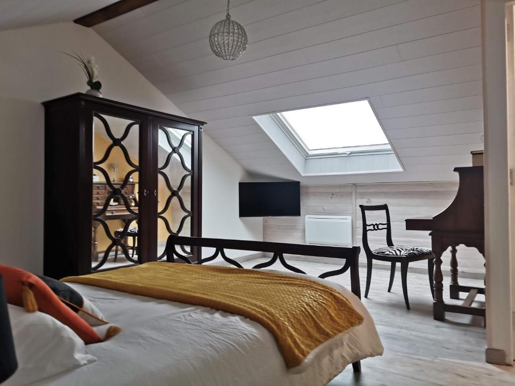 蒙特雷ETCHE ARGUINIA CHAMBRES HOTES的卧室配有床、书桌和钢琴