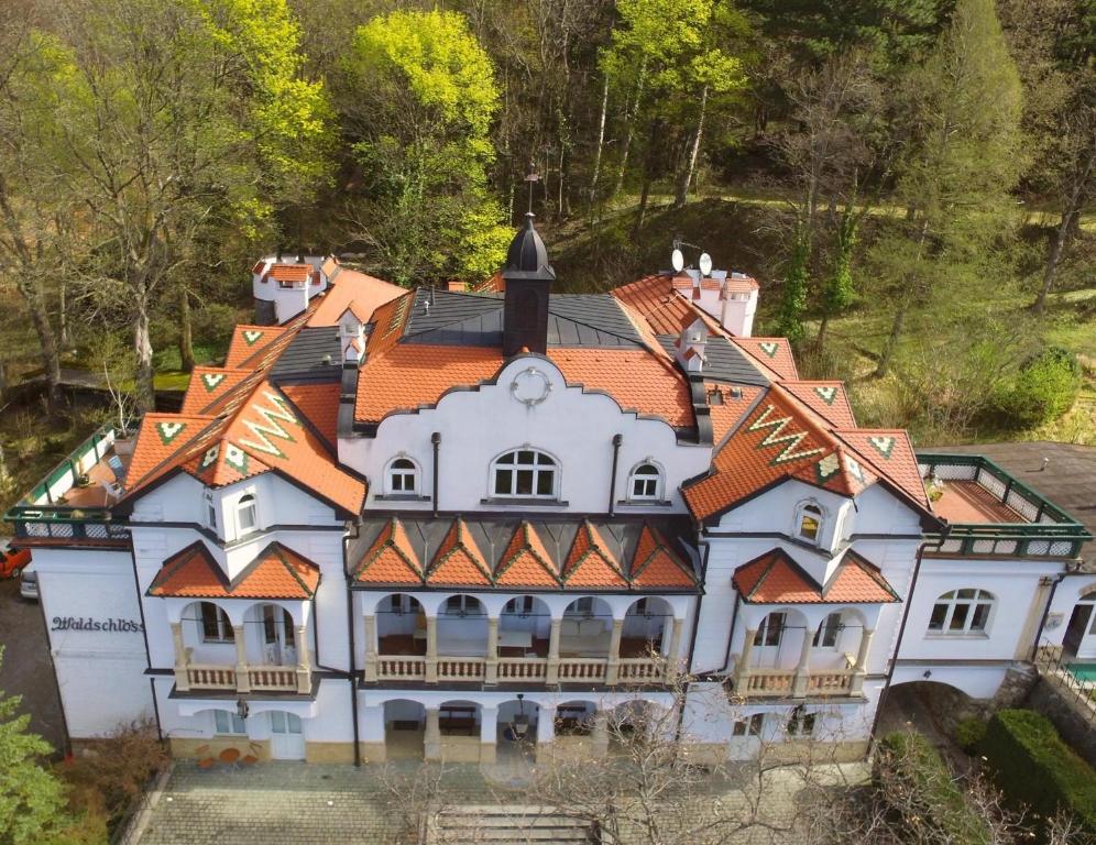 赖兴瑙Waldschlössl Schneedörfl的一座白色的大房子,有橙色的屋顶