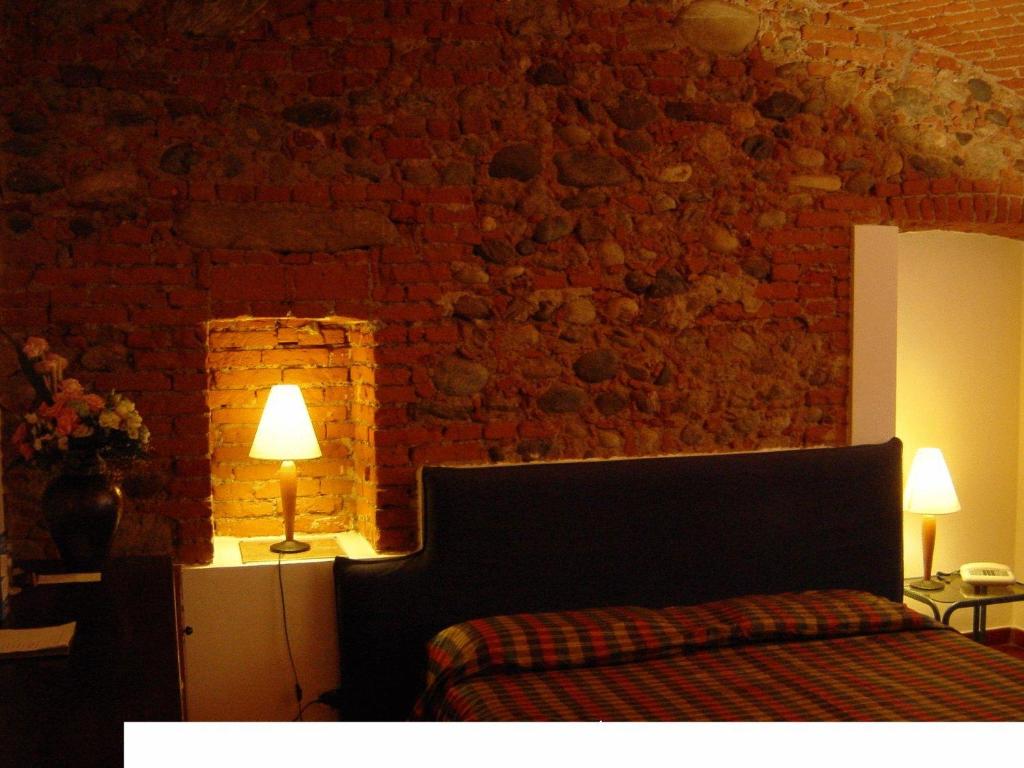 Candia Canavese德拉戈住宅酒店的一间卧室设有一张床和砖墙