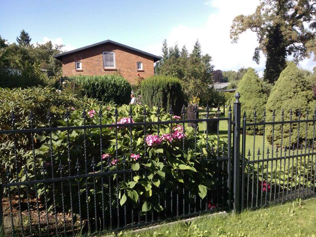 普特布斯Apartment in Putbus II的粉红色花朵房子前面的围栏