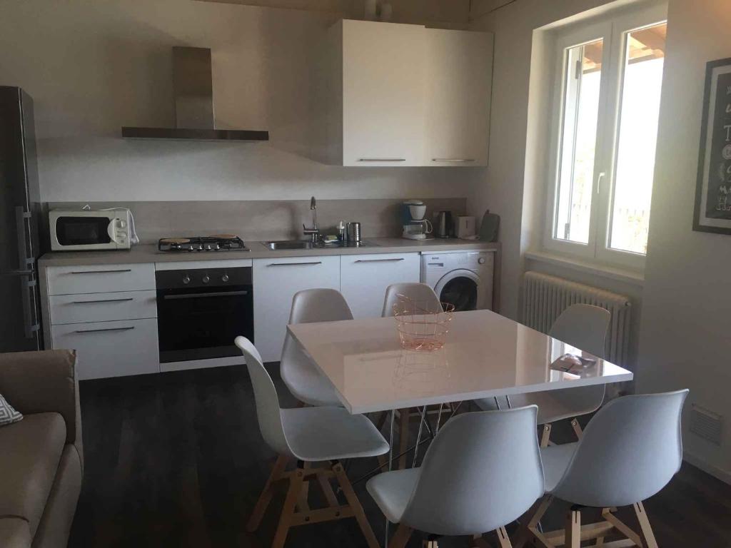 梅佐拉戈Apartments in Pur/Ledrosee 22640的一间带桌椅的厨房和一间带炉灶的厨房