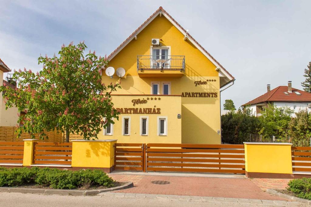 鲍洛通凯赖斯图尔Holiday home in Balatonmariafürdo 19492的前面有栅栏的黄色房子