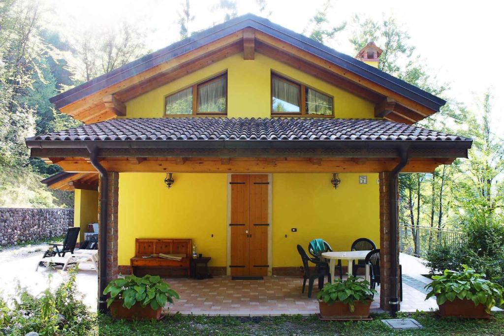 莱德罗Holiday home in Pieve di Ledro 22670的黄色房子前面有桌子