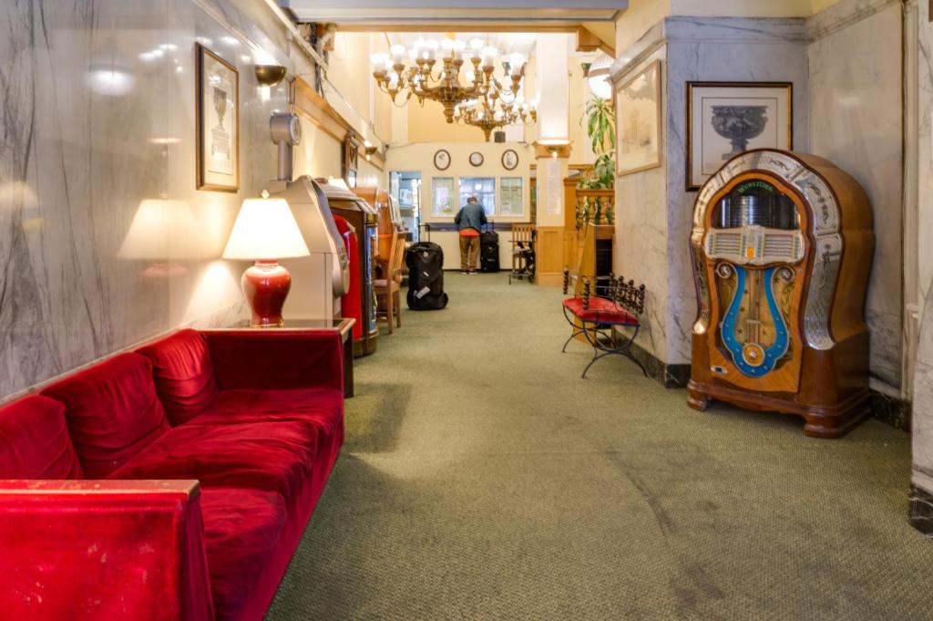 旧金山艾达广场酒店的客厅配有红色的沙发和桌子