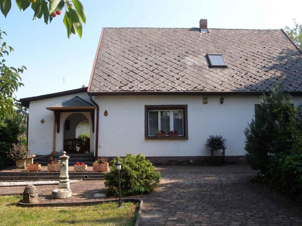 Balatonszabadi FürdőtelepHoliday home in Siofok/Balaton 19703的白色房屋,设有瓷砖屋顶