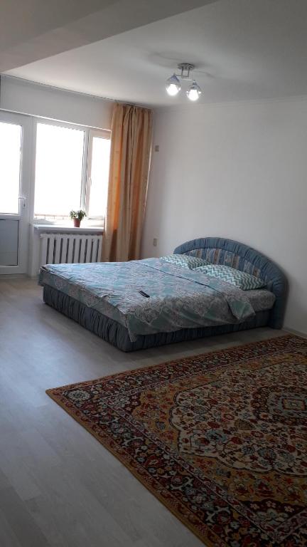 奎兹洛达Светлая квартира для гостей的卧室配有一张床,地板上铺有地毯