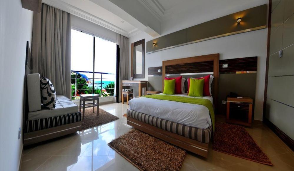 塔巴卡普雷斯蒂奇塔巴卡码头酒店的一间卧室配有一张带绿色和红色枕头的大床