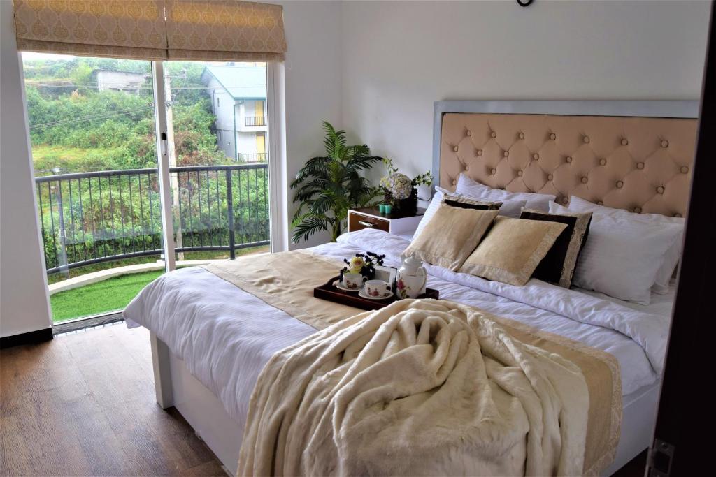 努沃勒埃利耶Lake Infinity Luxury Condos的一间卧室设有一张大床和大窗户