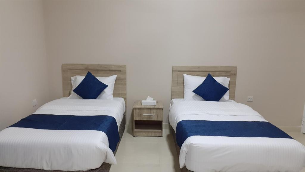 杜科姆Dar Al-Jwharah的蓝色和白色的客房内的两张床