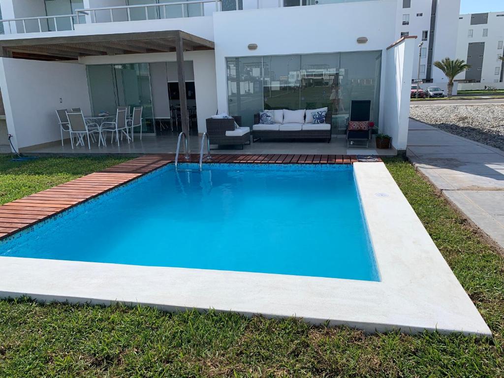帕拉卡斯Condominios Nauticos Nuevo Paracas的一座大蓝色游泳池,位于房子前
