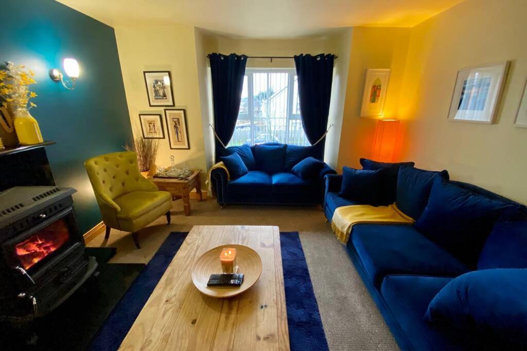 康多纳3 Bedroom House located in Centre of Carndonagh的客厅设有蓝色的沙发和壁炉