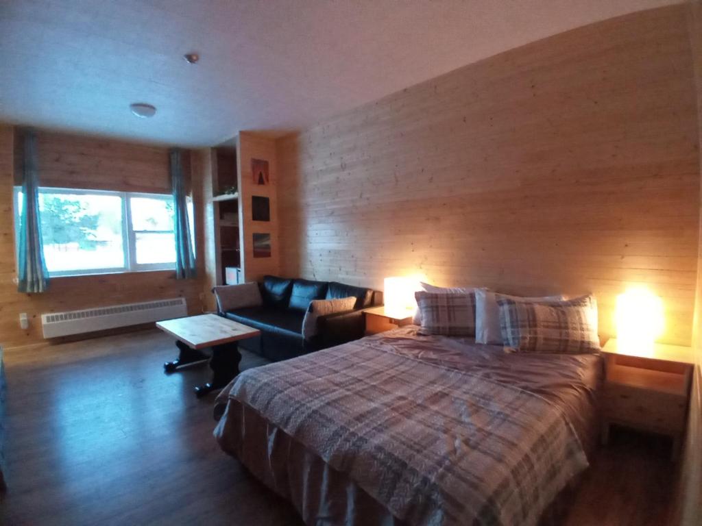 Killaloe StationSchoolhouse Inn的一间卧室配有一张大床和一张沙发