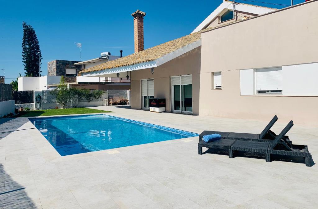 桑卢卡尔-德巴拉梅达Casa/Chalet Doñana的一座房子旁带躺椅的游泳池