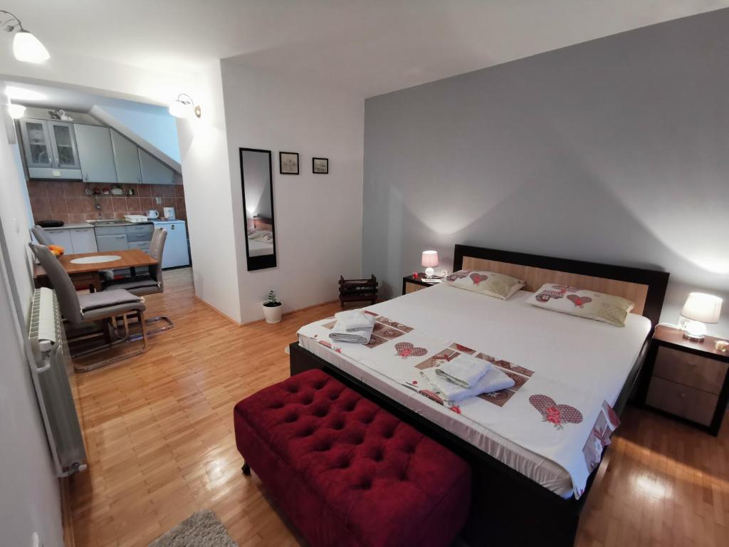 威尔帕扎Apartment Vukasevic的一间卧室设有一张大床和一张红色长凳