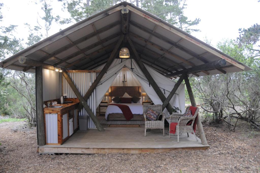 维德尼斯Heritage Glamping, Woodlands tent的帐篷内一间卧室,配有一张床和椅子