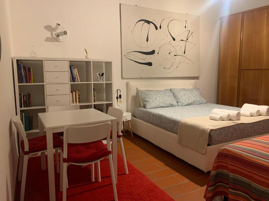 摩德纳La casa del Centro的一间卧室配有一张床、一张桌子和一张桌子