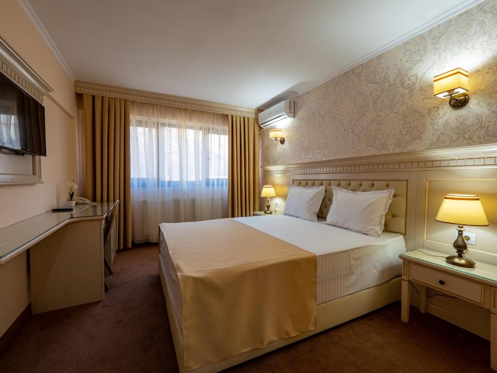 加拉茨Hotel Orient Galati的一间设有大床和窗户的酒店客房