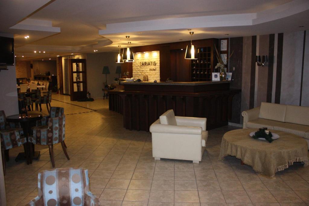 尼亚·卡利克拉提亚卡利亚蒂斯酒店的一间餐厅,设有配有椅子的大堂和一间酒吧