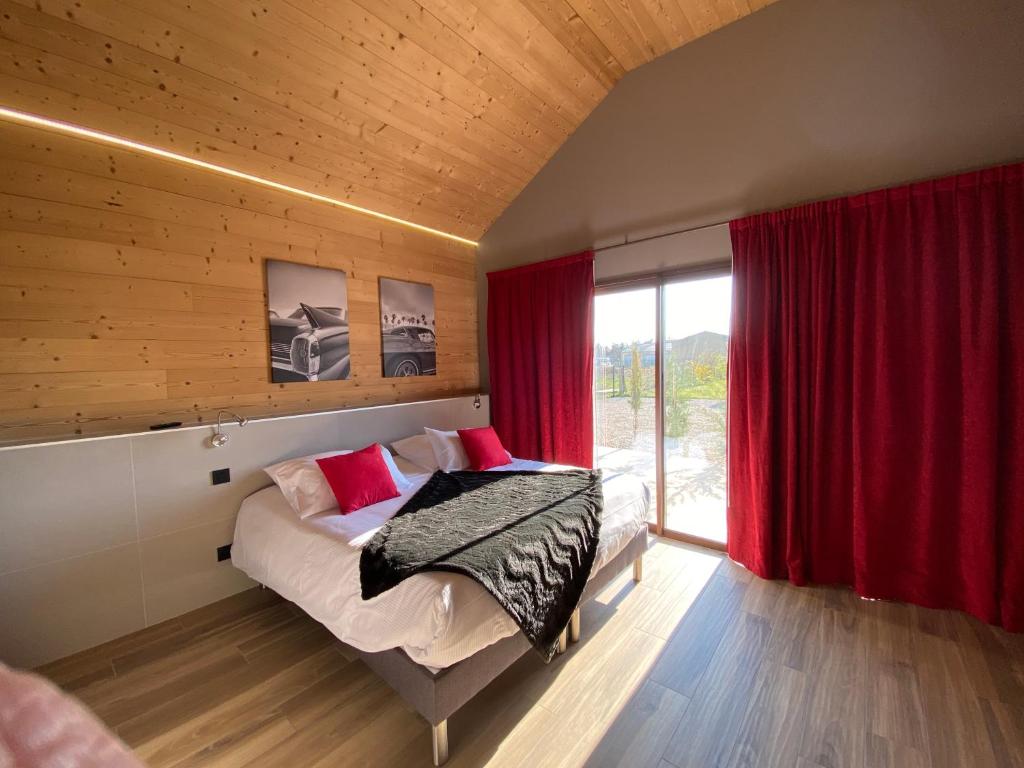 圣维尔巴斯World Hotel的一间卧室配有一张带红色窗帘的床和一扇窗户
